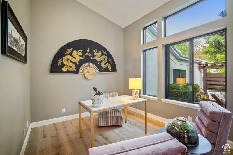 Office space with baseboards, wood finished floors, and lofted ceiling