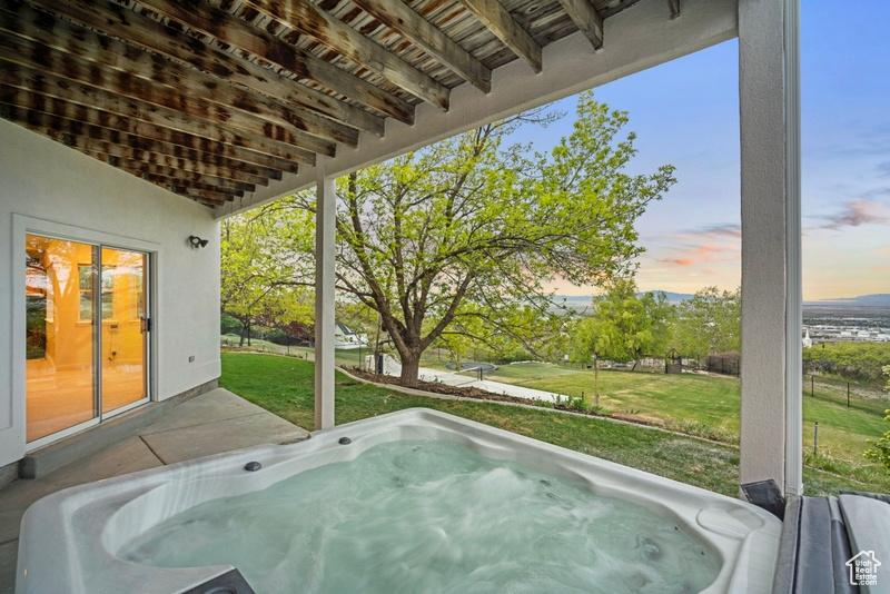 Wooden deck with a hot tub and a yard