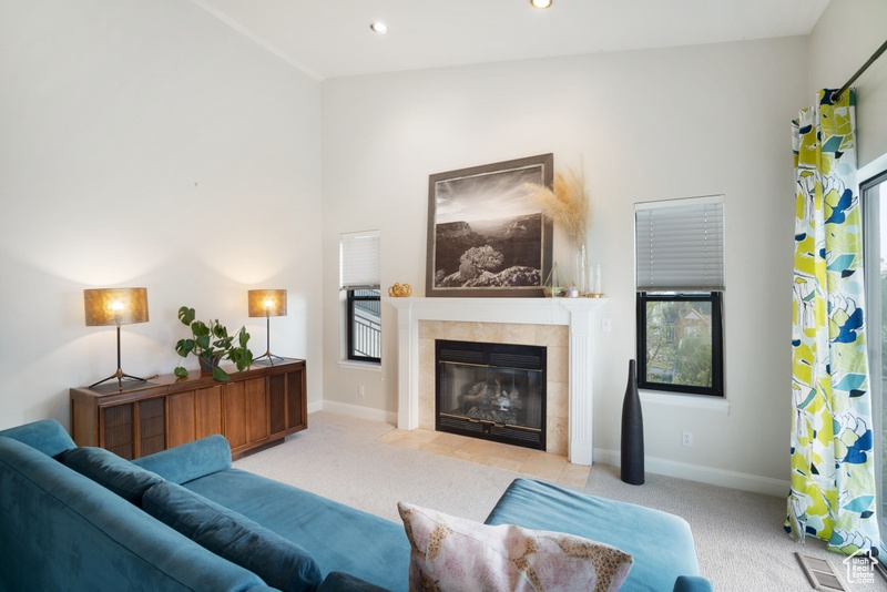 Living room featuring recessed lighting, baseboards, carpet, and a tile fireplace