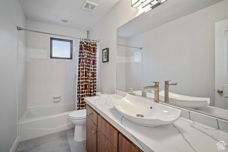 Bathroom featuring shower / bath combo, vanity, toilet, tile patterned floors, and visible vents