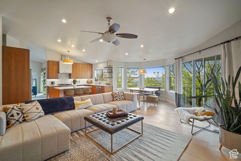 Living room with recessed lighting, light wood finished floors, ceiling fan, and vaulted ceiling