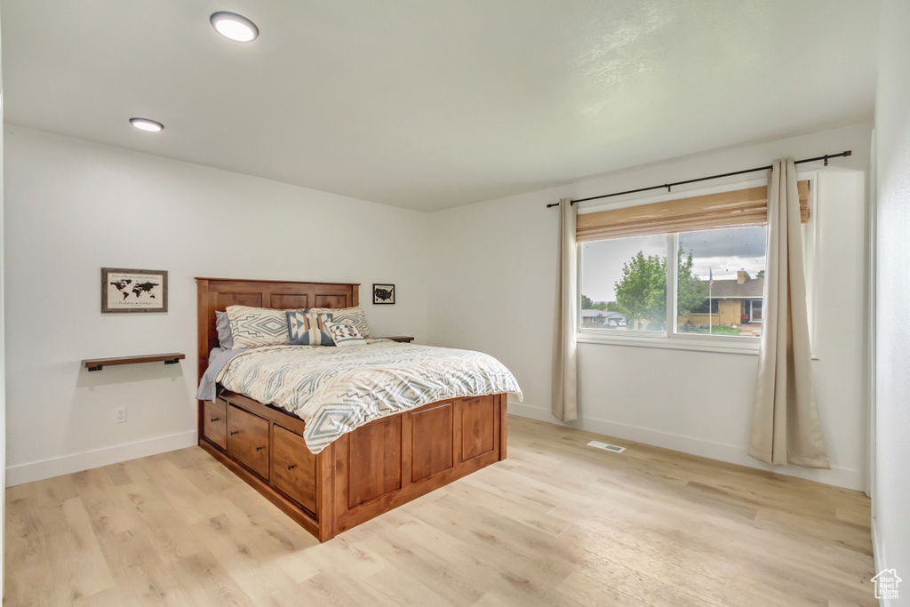Bedroom featuring baseboards, light wood-style flooring, and visible vents