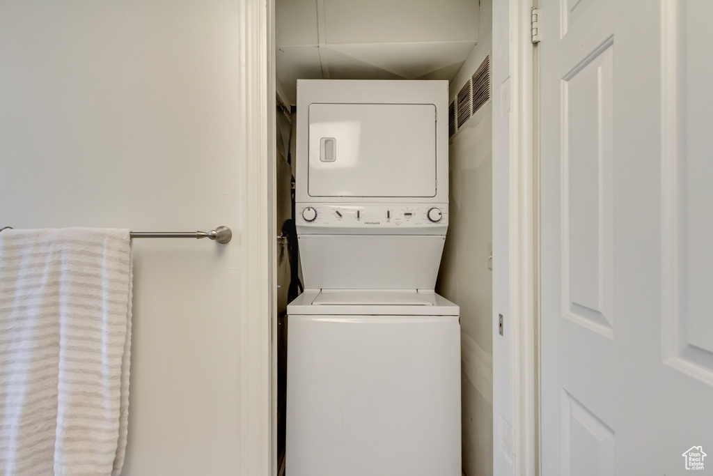 Laundry room featuring laundry area and stacked washer / drying machine