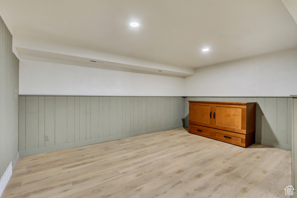 Bonus room featuring light wood-type flooring, wainscoting, and baseboards