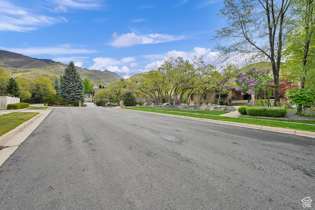 View of road featuring curbs, a mountain view, and sidewalks