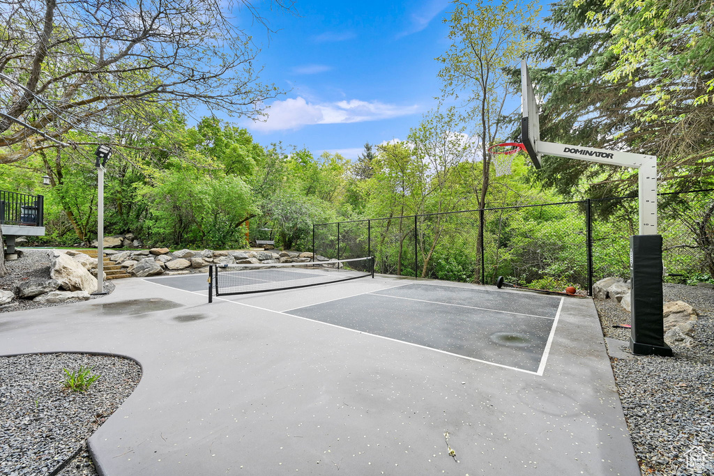 View of basketball court featuring fence and a tennis court