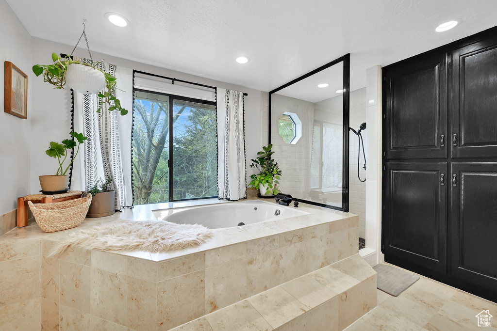 Full bath featuring recessed lighting, a tile shower, and a garden tub