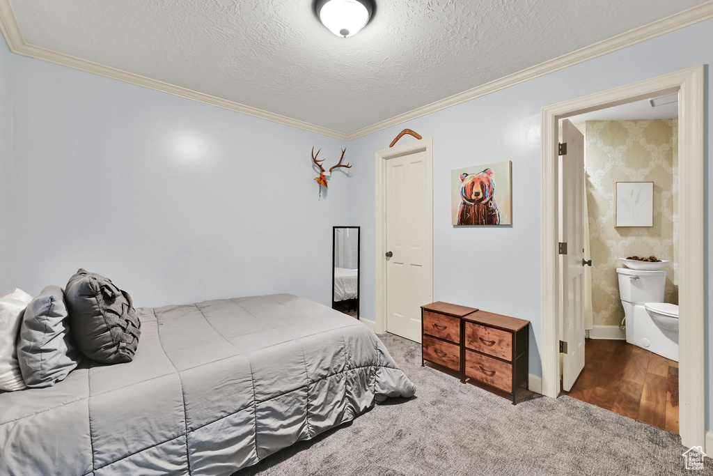 Bedroom featuring ornamental molding, carpet, and a textured ceiling