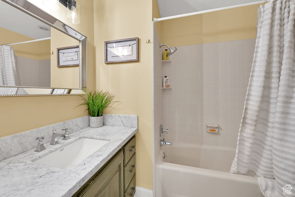 Bathroom featuring vanity and shower / tub combo with curtain