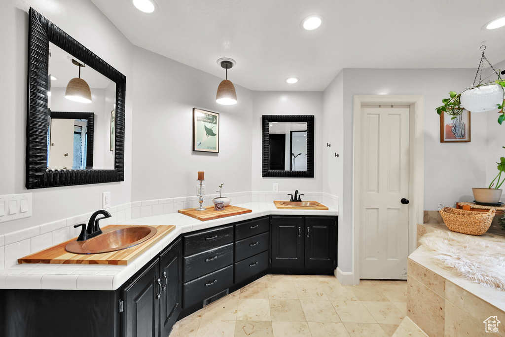 Bathroom with a sink, recessed lighting, and double vanity