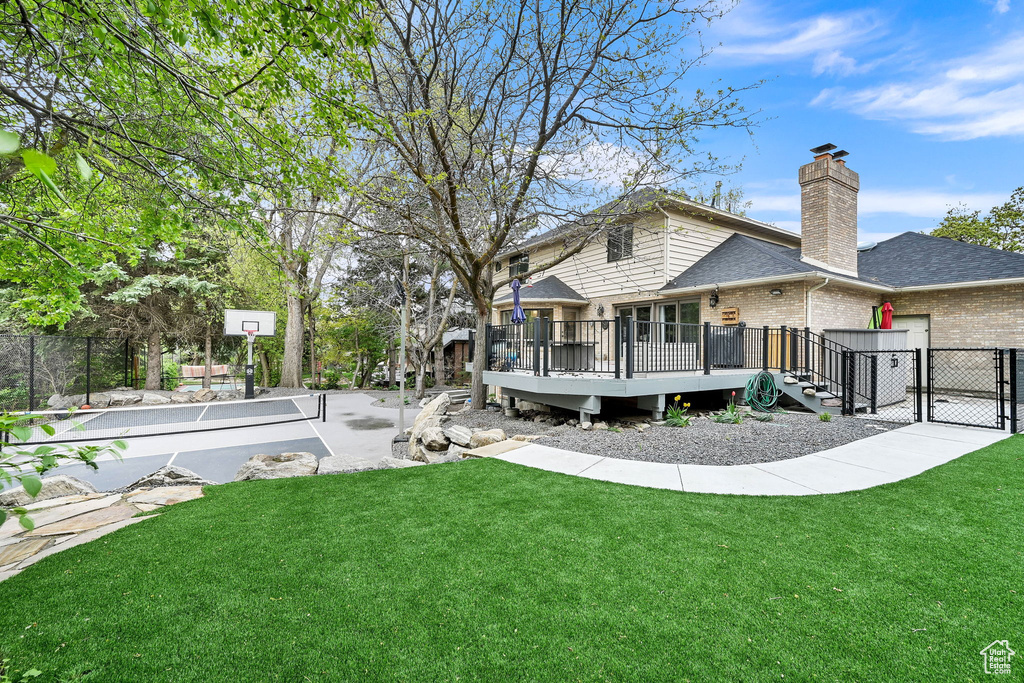 Rear view of property featuring fence, a gate, a yard, and brick siding