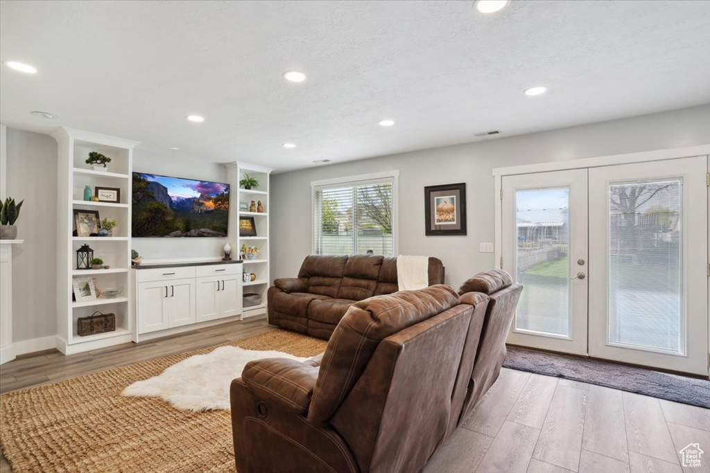 Living room featuring recessed lighting, french doors, light wood finished floors, and visible vents