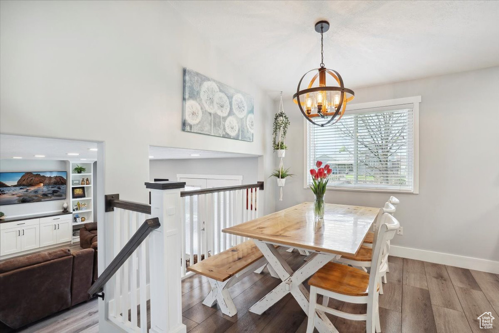 Dining room with light wood-type flooring, baseboards, and a chandelier