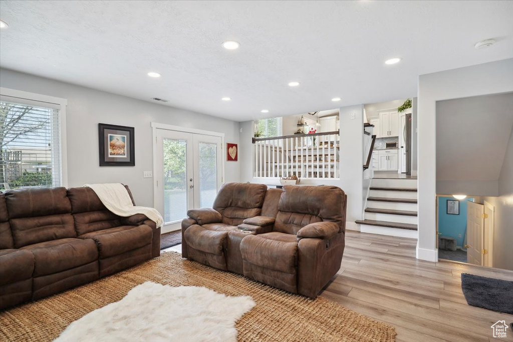 Living area featuring recessed lighting, stairway, french doors, and light wood finished floors