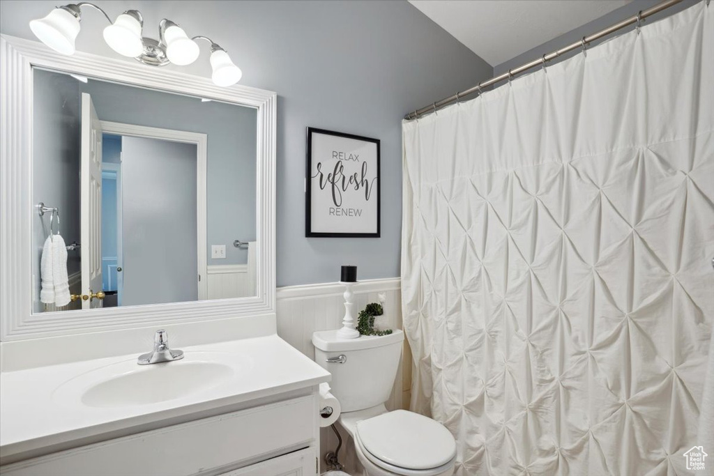 Bathroom featuring vanity, wainscoting, and toilet