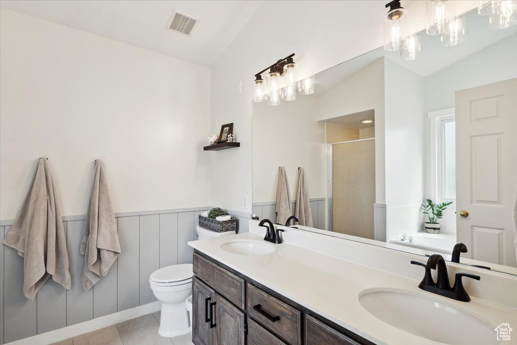 Bathroom featuring visible vents, a sink, lofted ceiling, and a stall shower