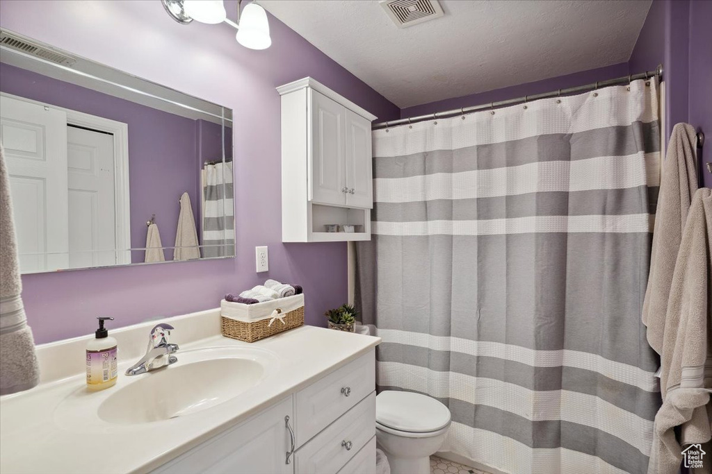 Full bathroom featuring visible vents, toilet, and vanity