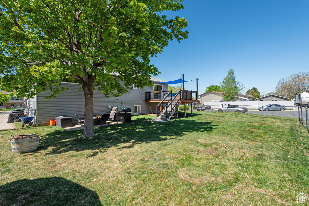 View of yard featuring a fenced backyard, a deck, and stairway