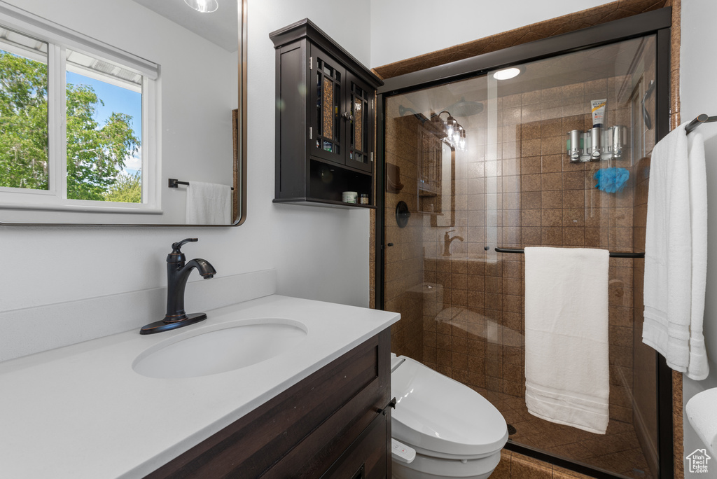 Full bathroom with vanity, a shower stall, and toilet