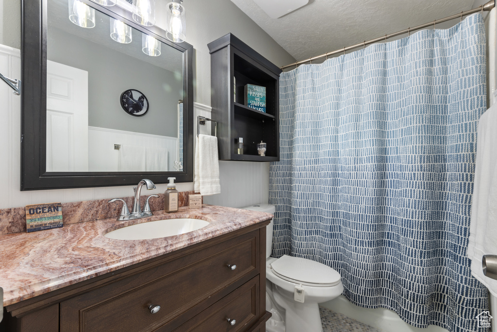 Full bath featuring vanity, a shower with shower curtain, and toilet