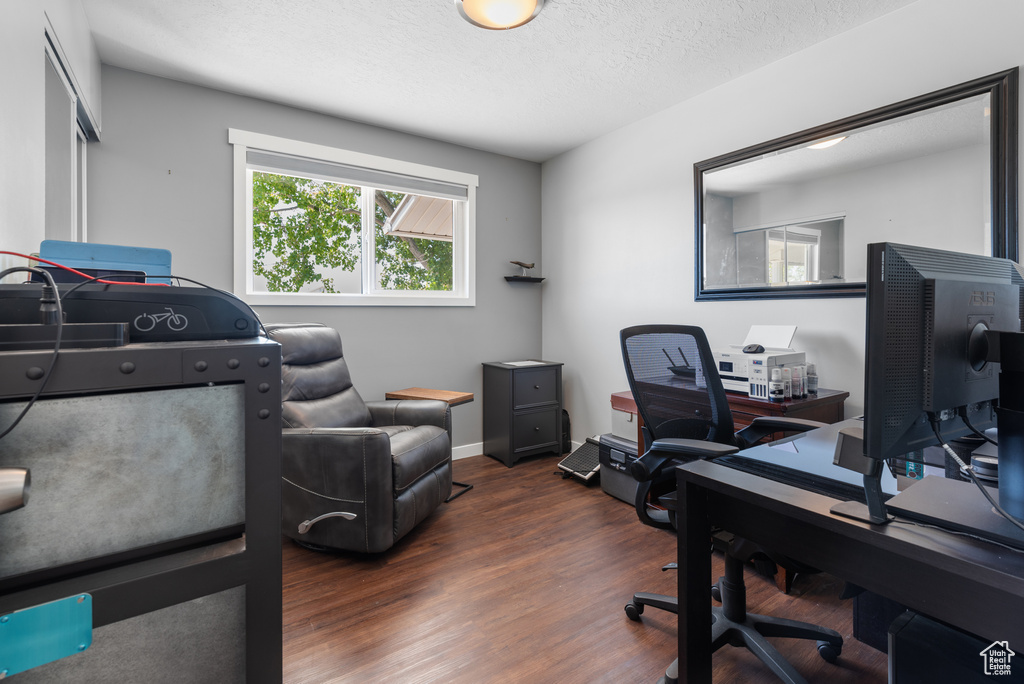 Office area featuring a textured ceiling, baseboards, and wood finished floors