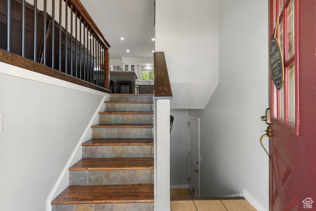 Stairs featuring baseboards, recessed lighting, and tile patterned flooring