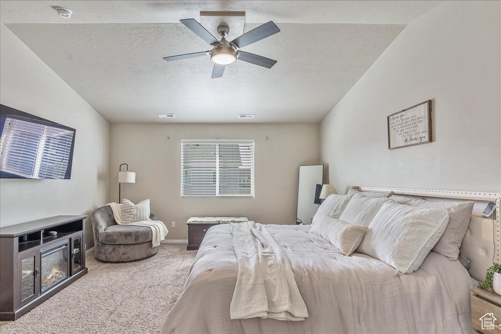 Carpeted bedroom featuring baseboards, a textured ceiling, and ceiling fan