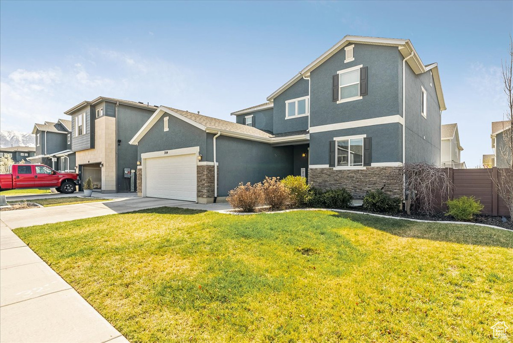 Craftsman house with concrete driveway, an attached garage, stone siding, and stucco siding