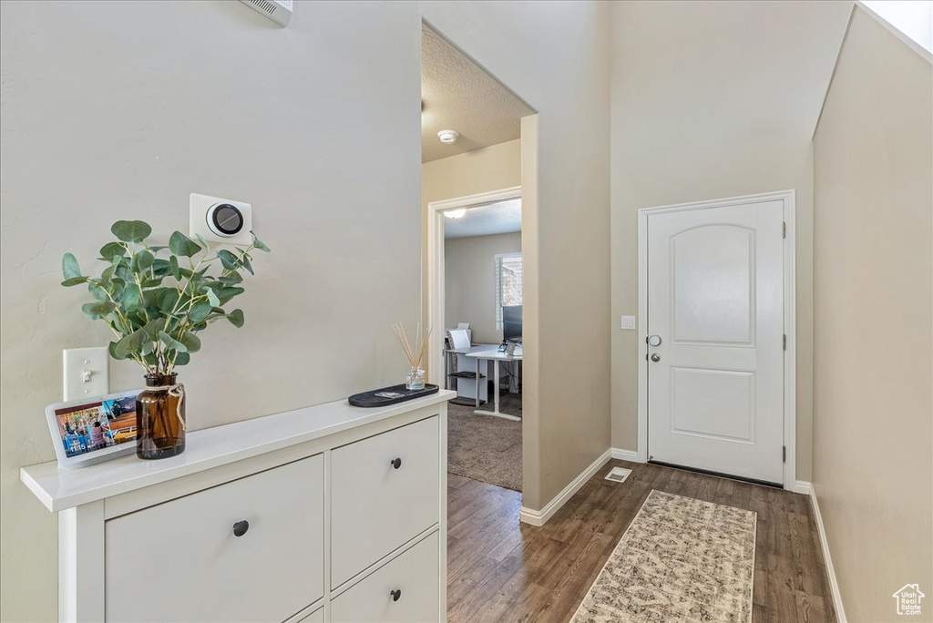 Foyer with baseboards and wood finished floors