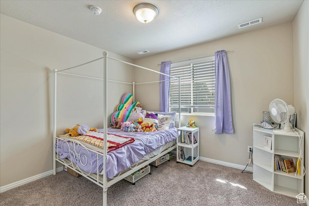 Carpeted bedroom featuring visible vents and baseboards