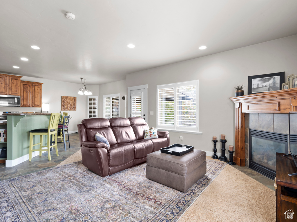 Living area with a tile fireplace, recessed lighting, and a notable chandelier