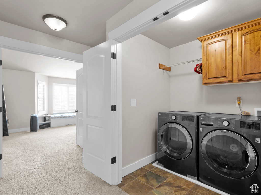 Laundry room with separate washer and dryer, baseboards, and cabinet space