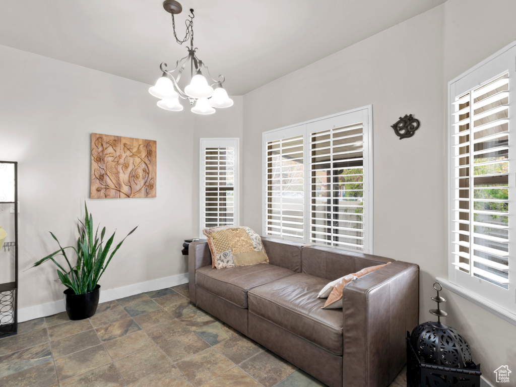 Living room with stone finish floor, baseboards, and an inviting chandelier