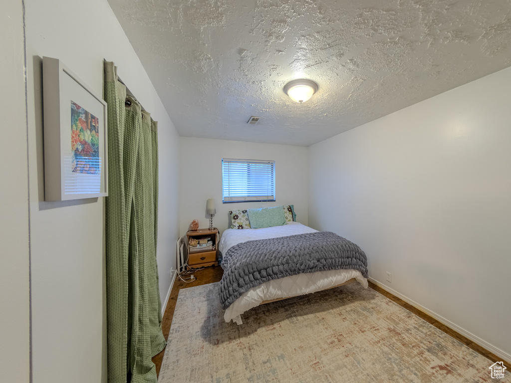 Bedroom featuring baseboards and a textured ceiling