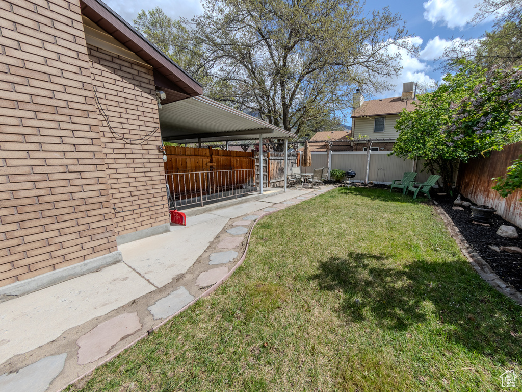 View of yard featuring a fenced backyard and a patio