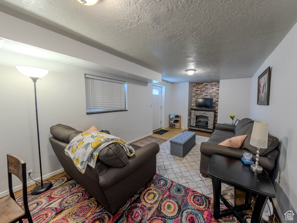 Living room featuring a textured ceiling, baseboards, and a fireplace
