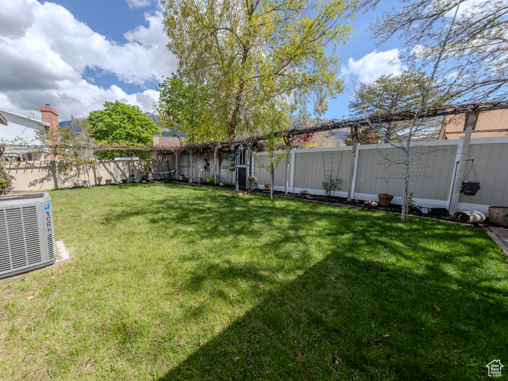 View of yard with a fenced backyard and central air condition unit