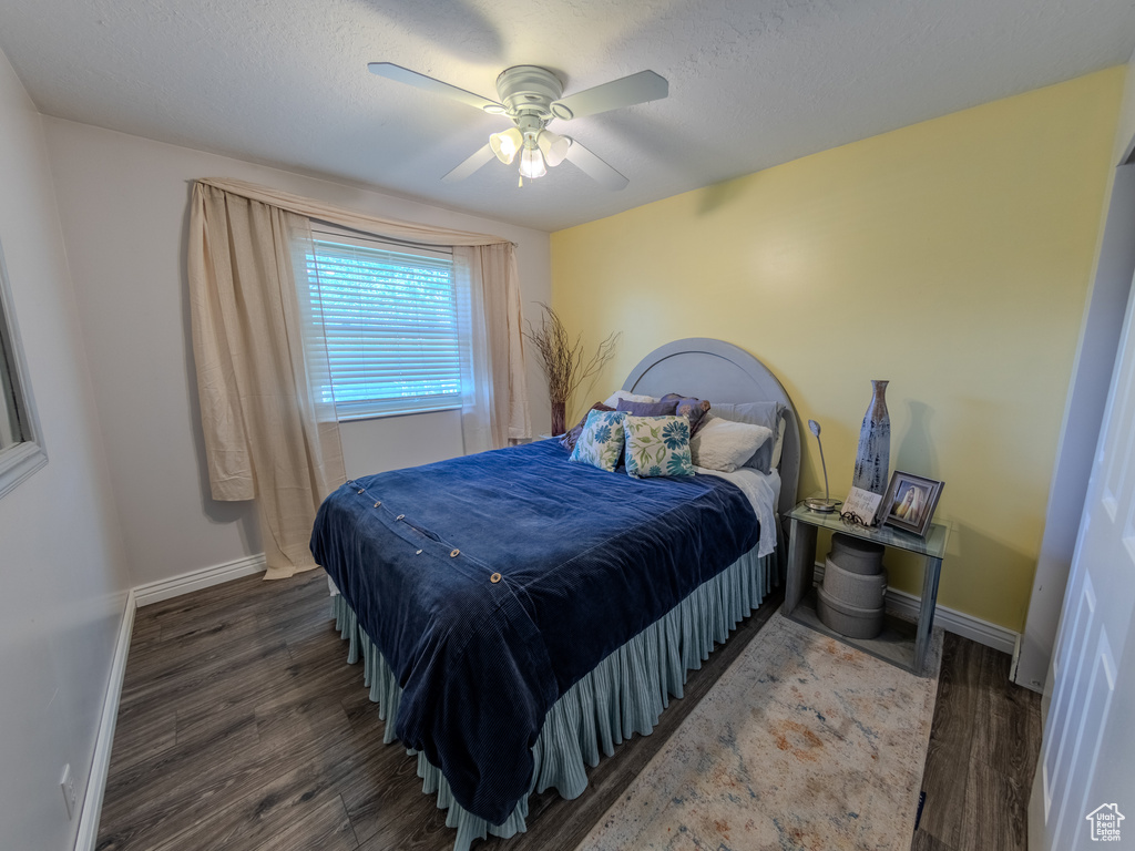 Bedroom featuring baseboards, a ceiling fan, and wood finished floors