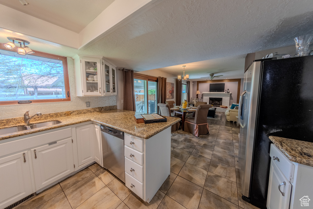 Kitchen featuring stainless steel appliances, open floor plan, plenty of natural light, and a peninsula