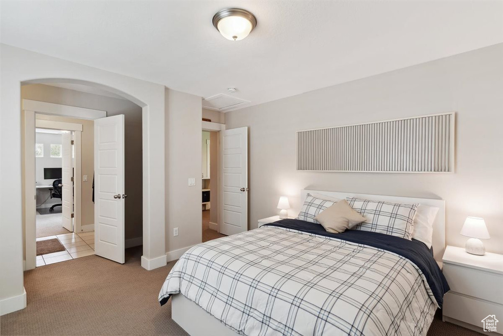 Carpeted bedroom featuring arched walkways and baseboards