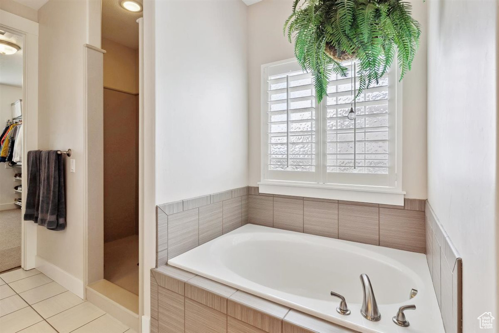 Bathroom with tile patterned floors, a shower stall, and a garden tub
