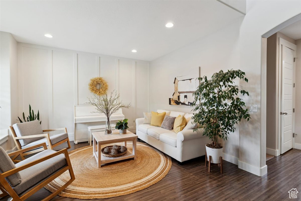 Living room featuring arched walkways, baseboards, recessed lighting, and wood finished floors