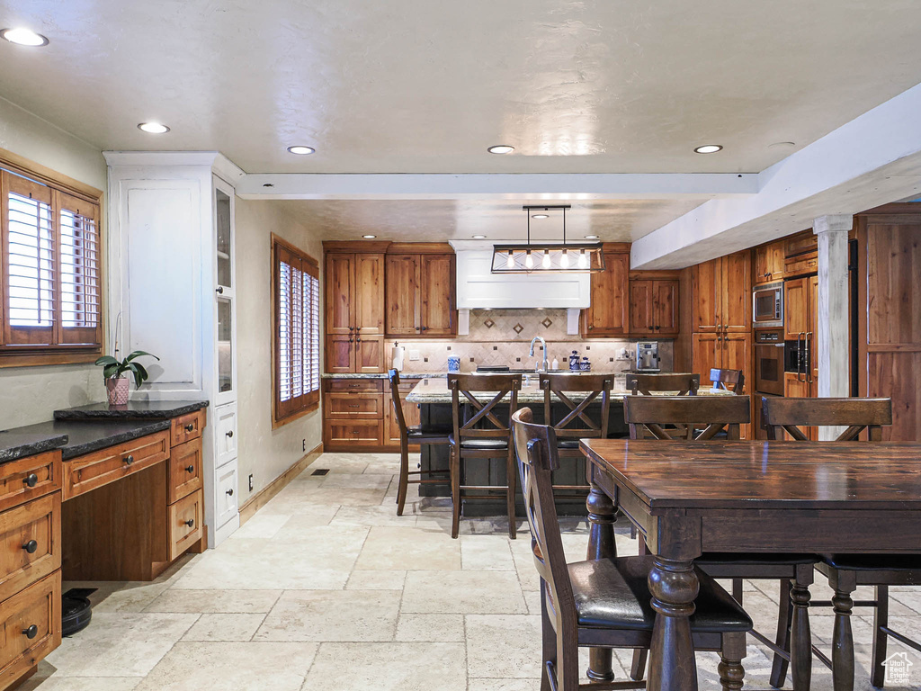 Dining room featuring baseboards, recessed lighting, and stone tile flooring