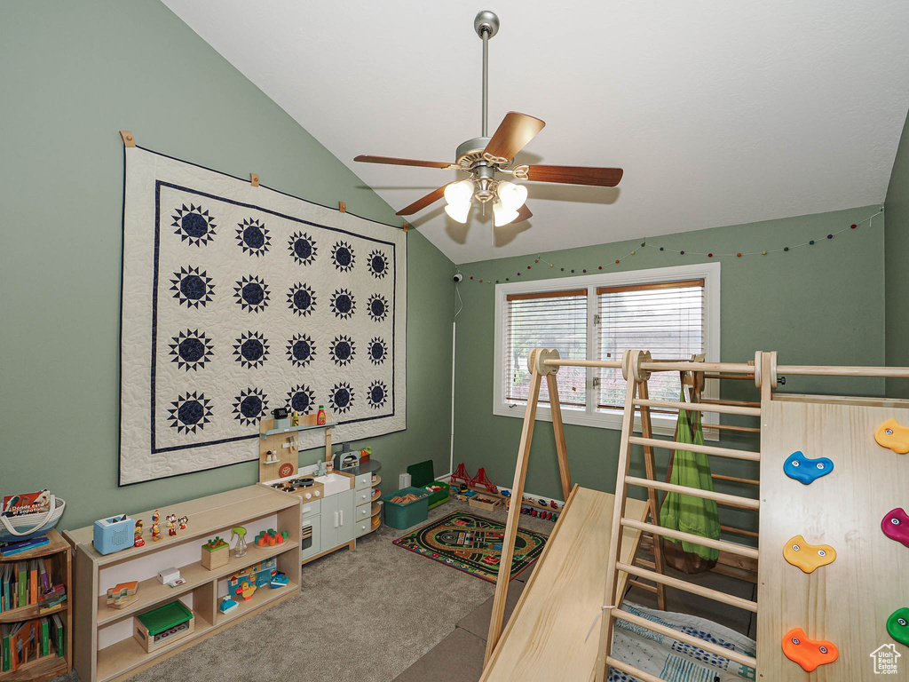 Rec room featuring carpet flooring, a ceiling fan, and vaulted ceiling