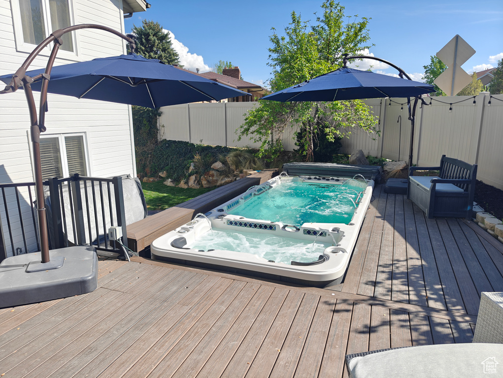 View of pool featuring a fenced backyard, hot tub deck surround, and a deck