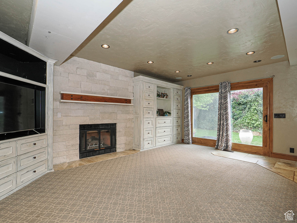 Unfurnished living room featuring baseboards, a fireplace, carpet flooring, and recessed lighting