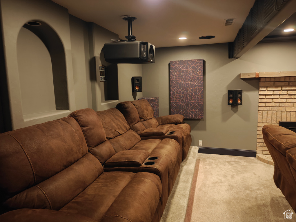 Carpeted home theater with visible vents, a fireplace, baseboards, recessed lighting, and arched walkways