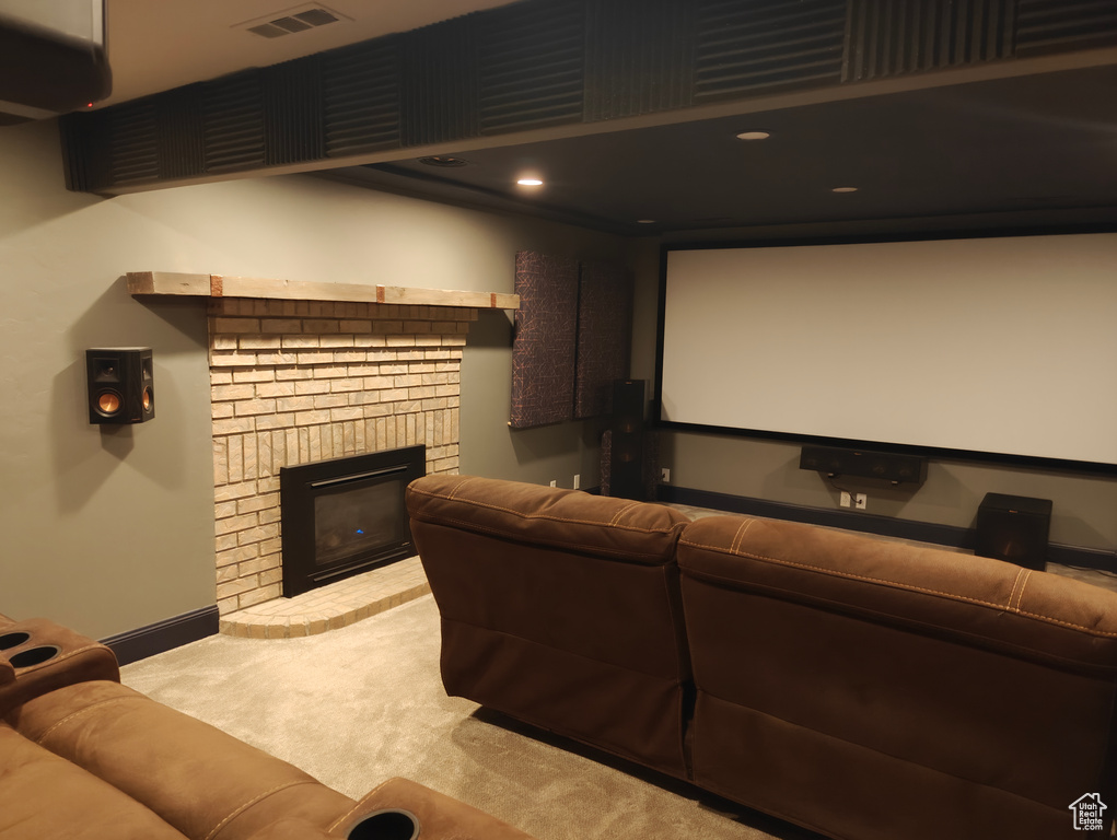 Home theater room with carpet floors, baseboards, a fireplace, and visible vents