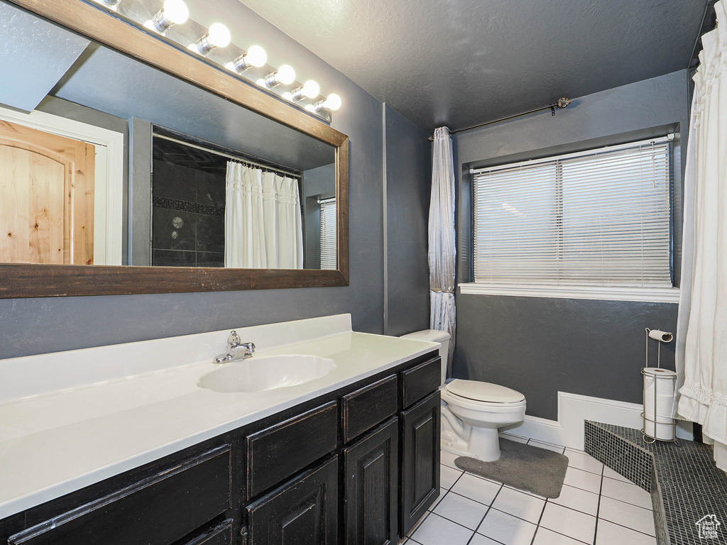 Full bath with tile patterned flooring, vanity, toilet, a shower with shower curtain, and visible vents