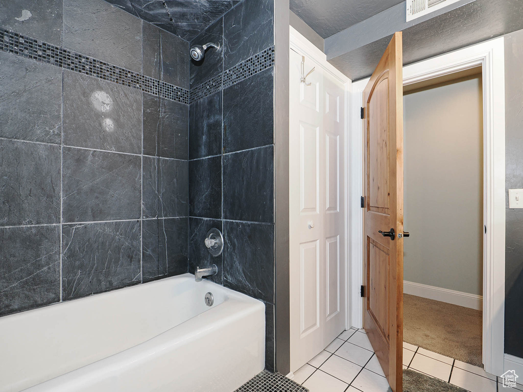 Full bath with tile patterned floors, baseboards, bathing tub / shower combination, and visible vents